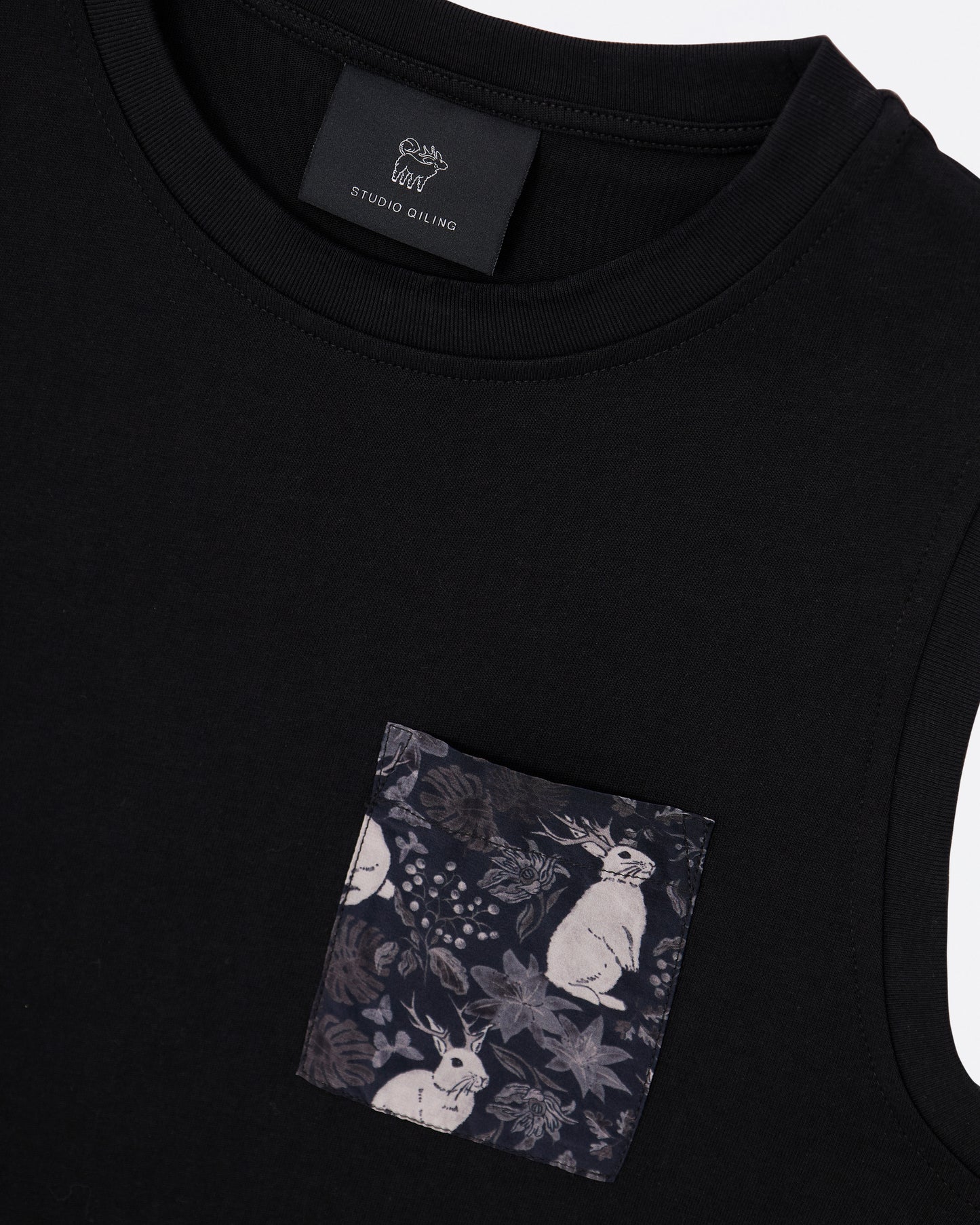 Black cotton tank dress with a pocket featuring a hand drawn floral and rabbit pattern