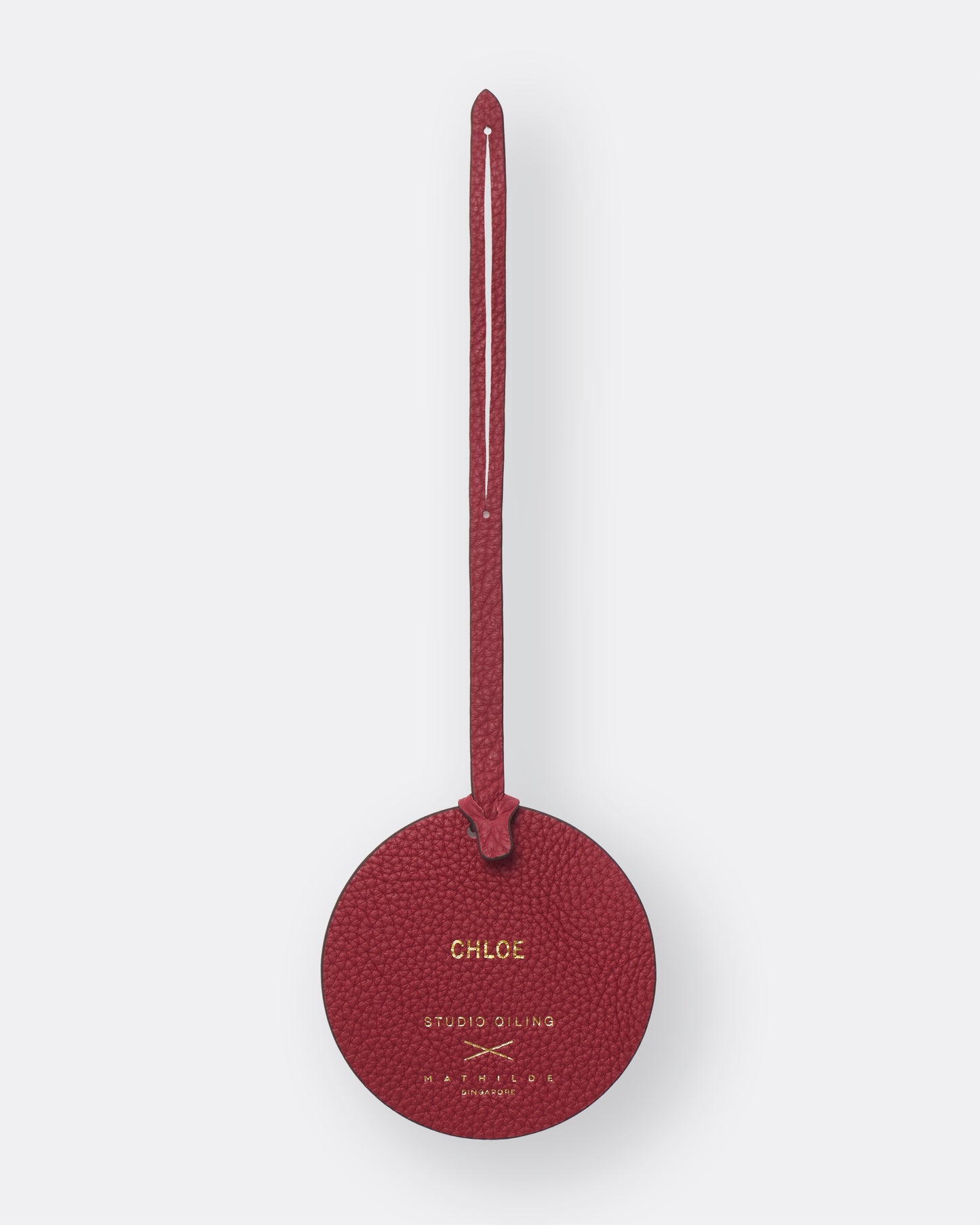 Reverse of red poppy leather bag charm with gold foil name personalisation