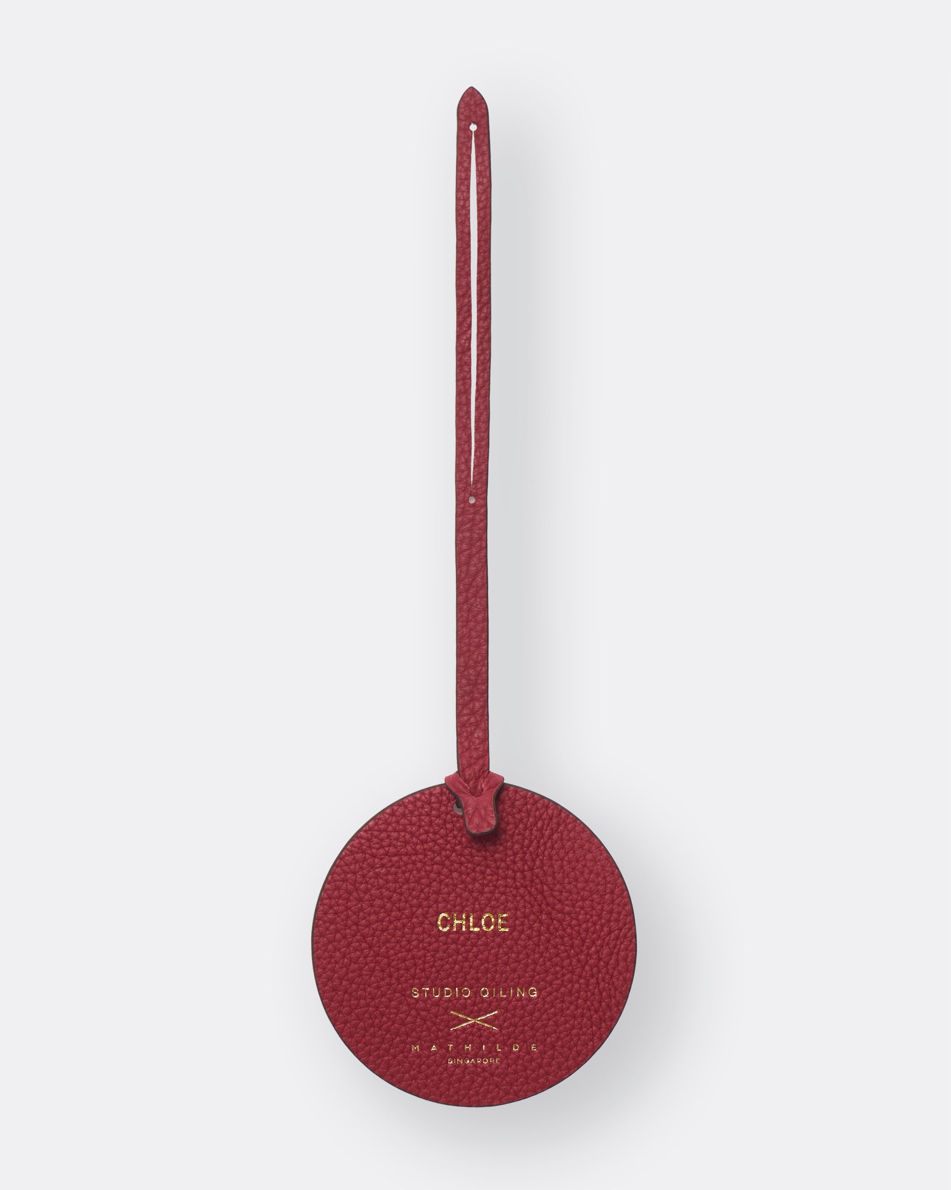 Reverse of red poppy leather bag charm with gold foil name personalisation