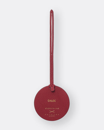 Reverse of red poppy leather bag charm with gold foil name personalisation