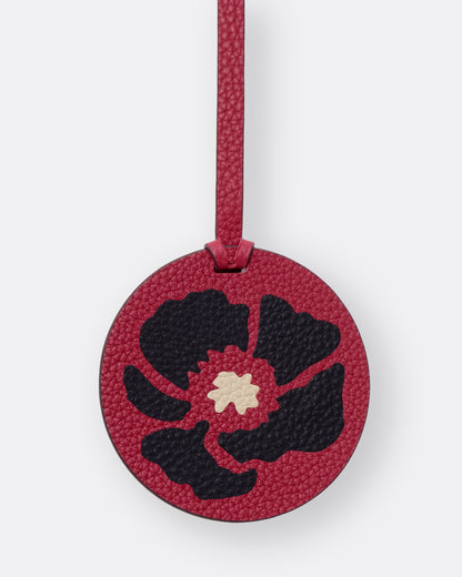 Close-up of black poppy leather marquetry inlay on round red bag charm