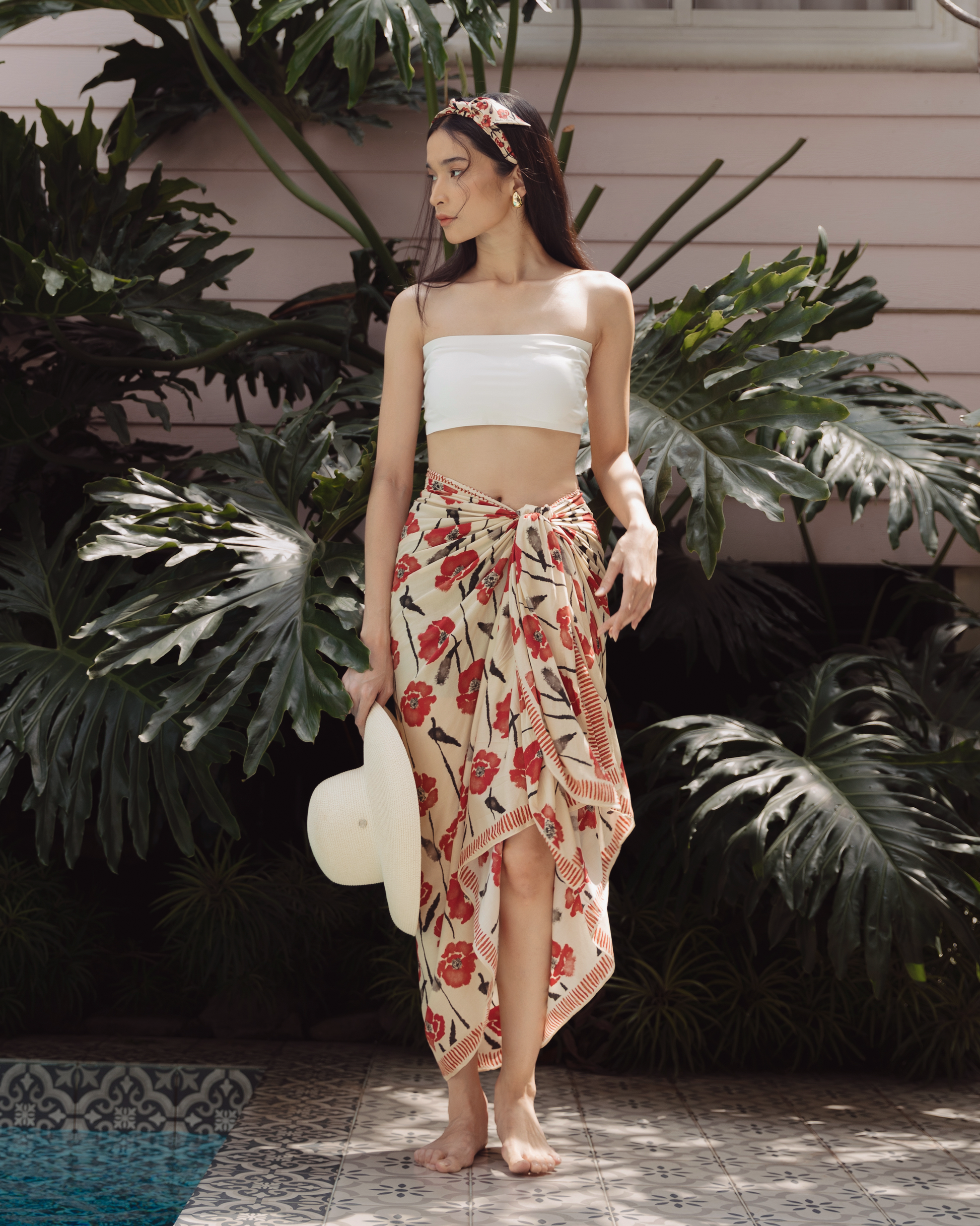 Woman wearing Dancing Poppies Mod pareo as a halter dress — Studio Qiling hand-drawn floral luxury resort pareo Singapore