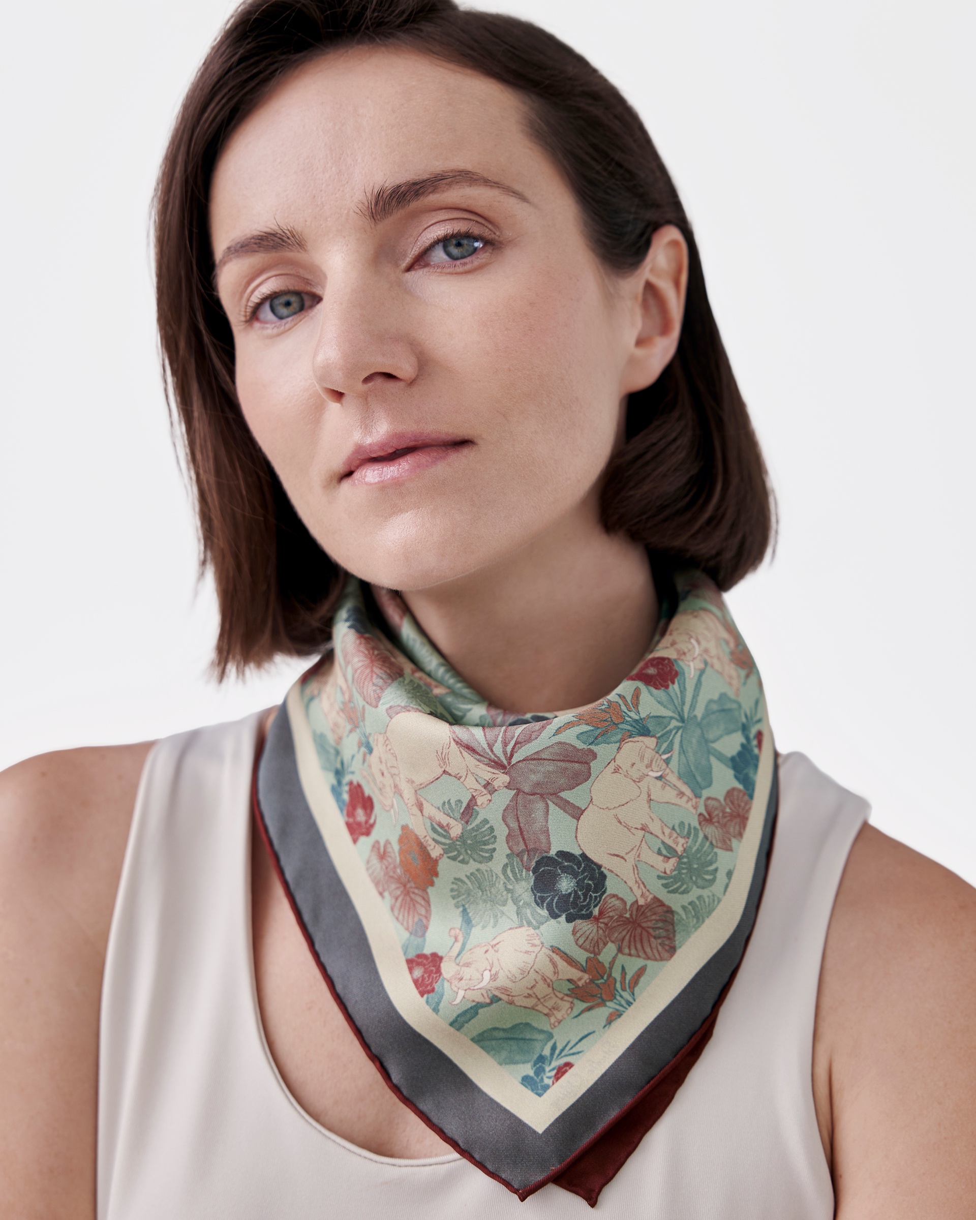 Woman wearing Elephant Teal Woods reversible silk scarf as a neck wrap — Studio Qiling hand-drawn elephant print luxury scarf