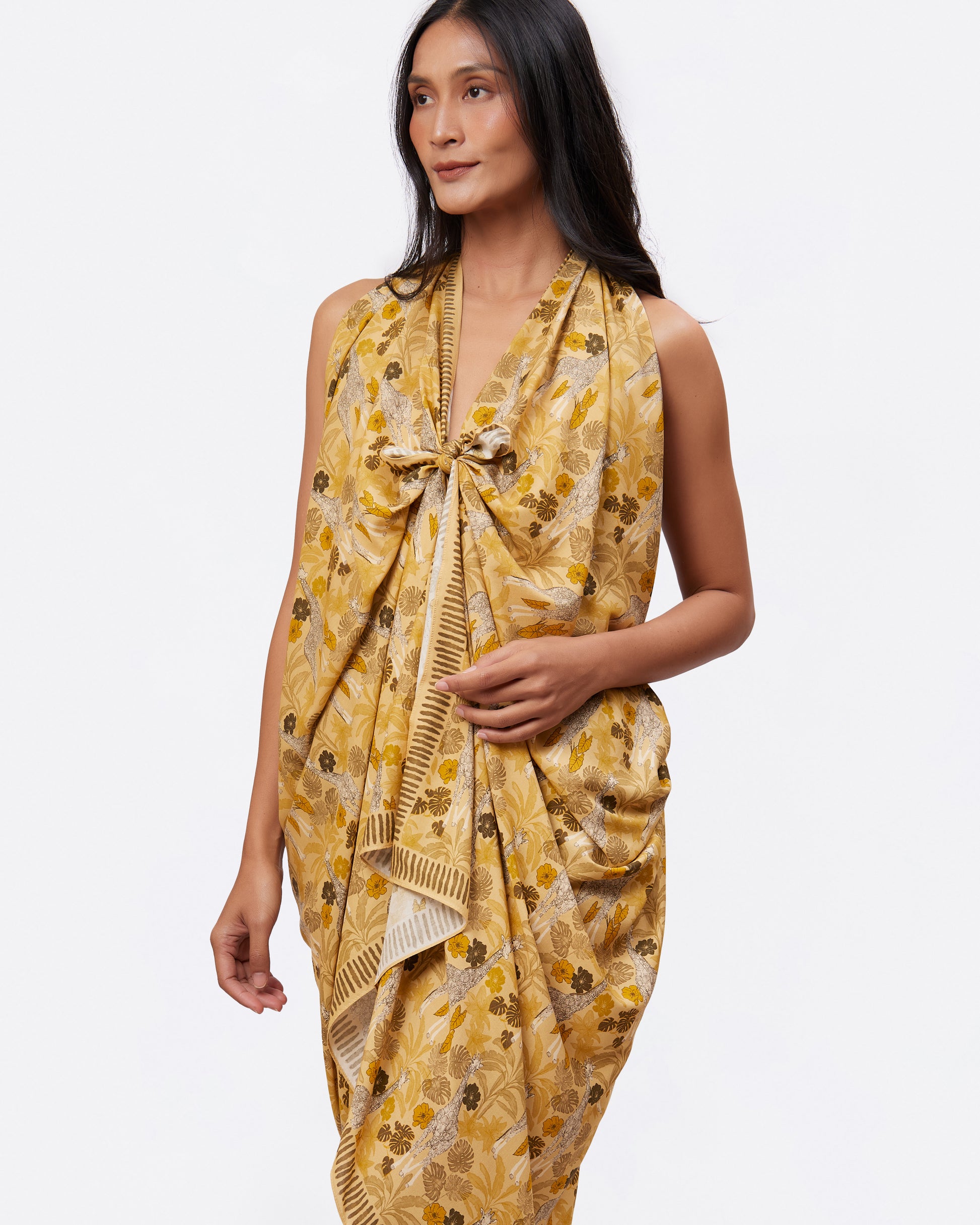 Woman wearing a yellow pareo with giraffe print as a dress 