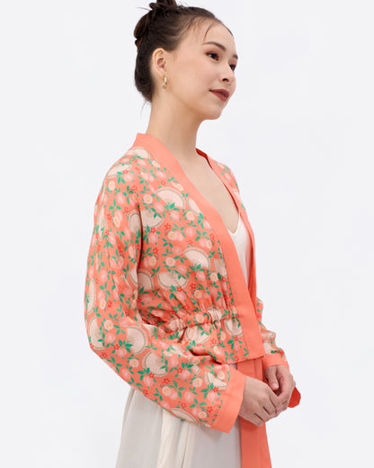 Woman wearing a silk blend patterned kimono-style jacket with a ribbon detail