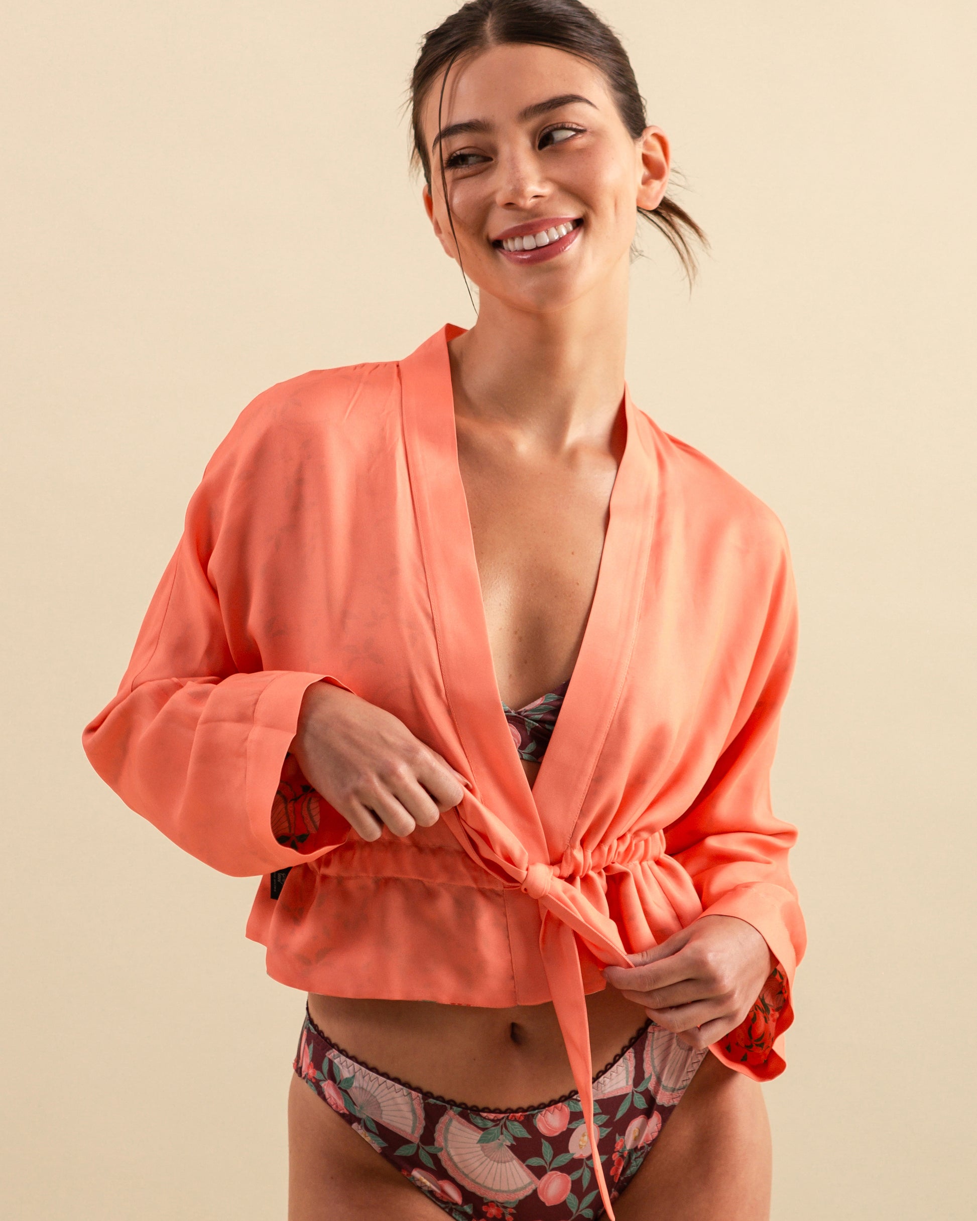 Studio Qiling x Perk by Kate. Woman wearing a coral kimono style cover up over a patterned lingerie
