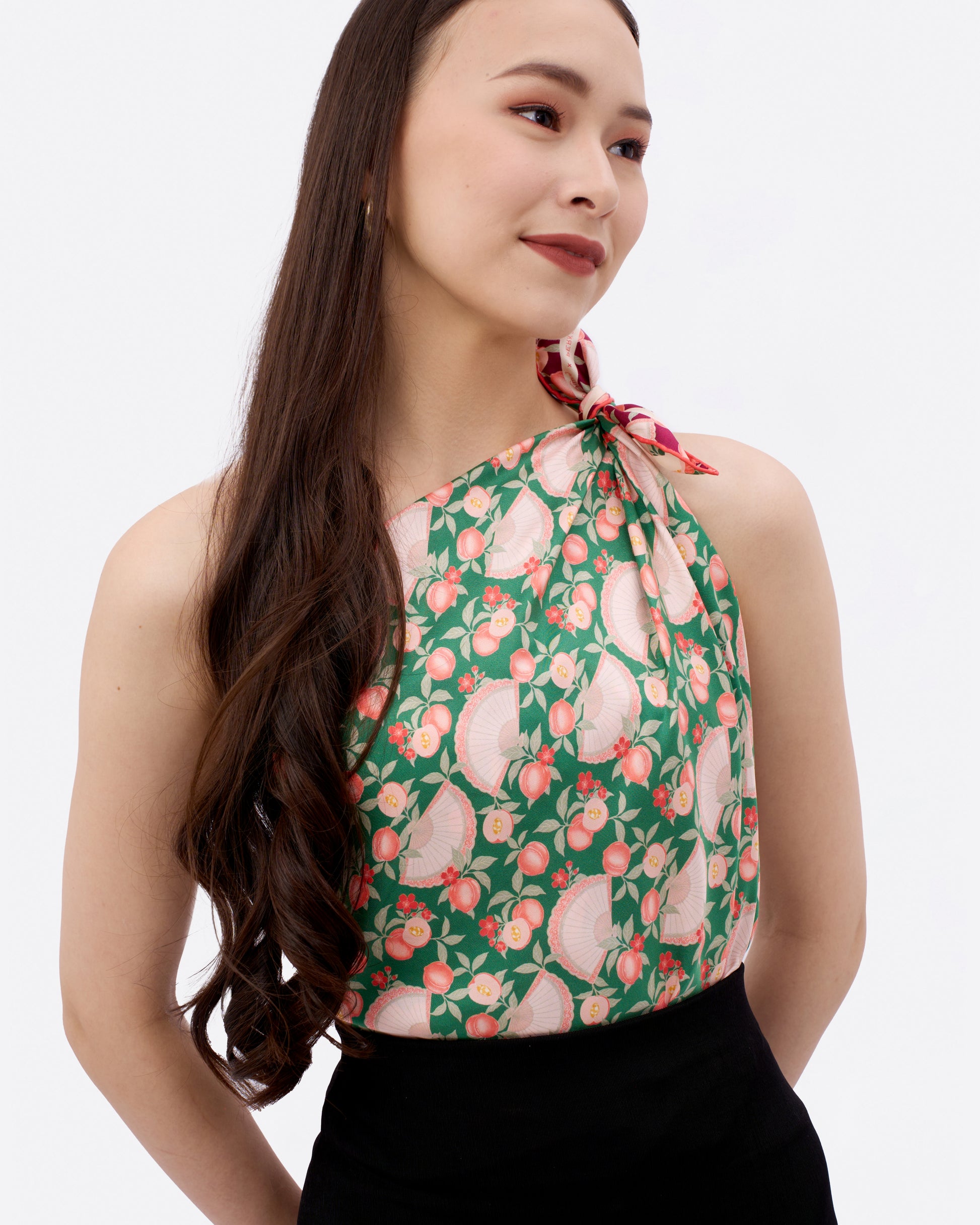 Woman wearing a emerald green reversible silk scarf as a toga top