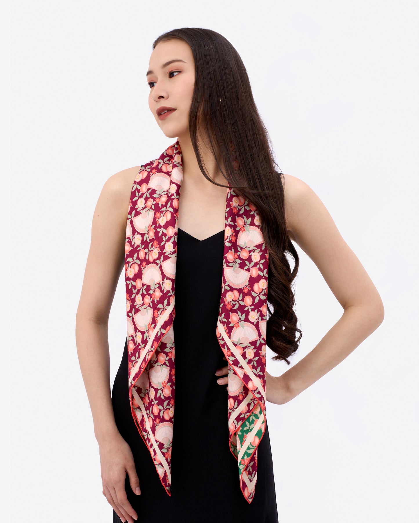Woman wearing a deep red colour reversible silk scarf with hand-drawn prints