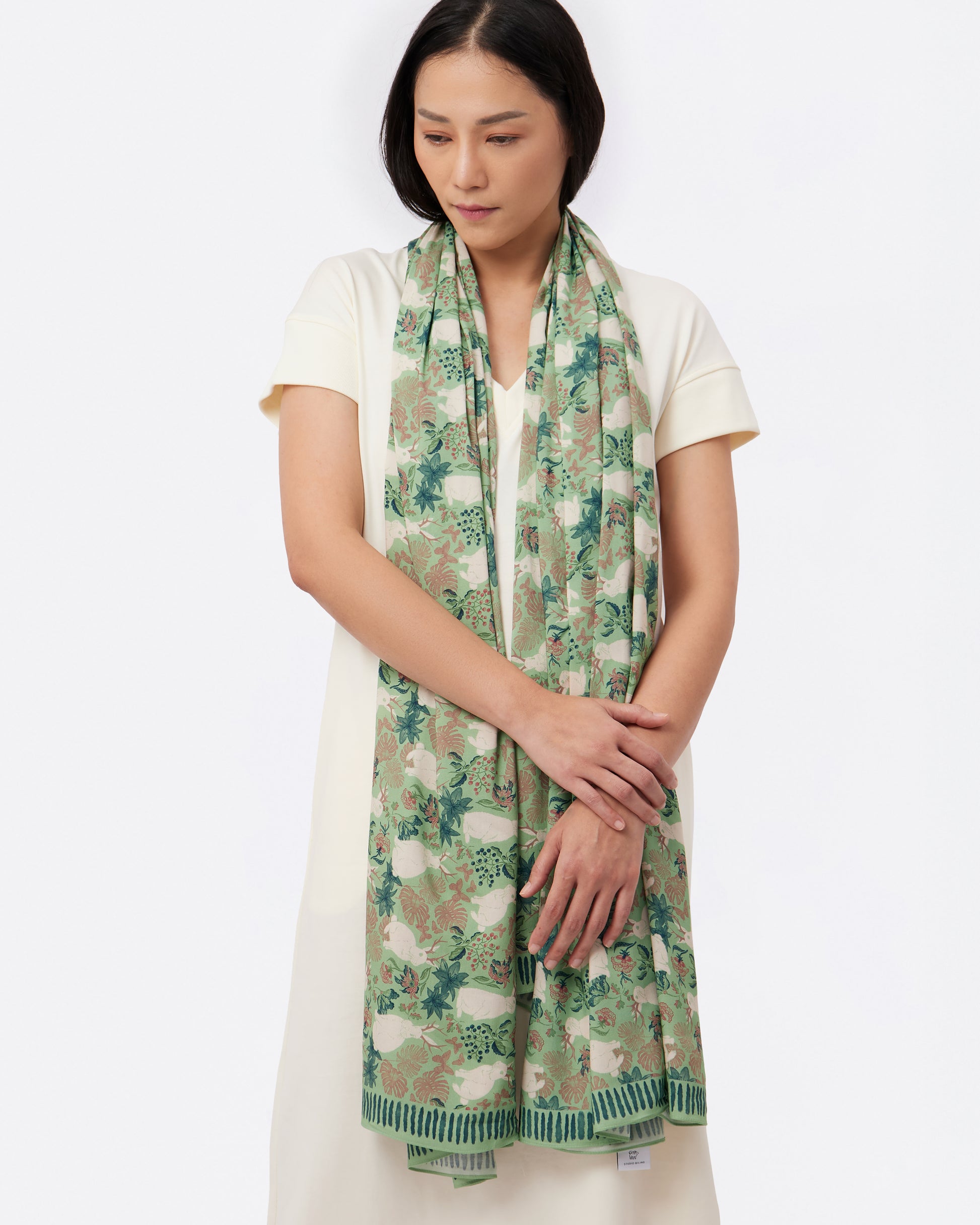 Woman wearing a green shawl with hand drawn jackalope print