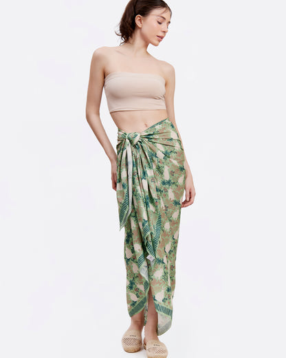 Woman wearing a strapless top and green patterned pareo as a sarong skirt