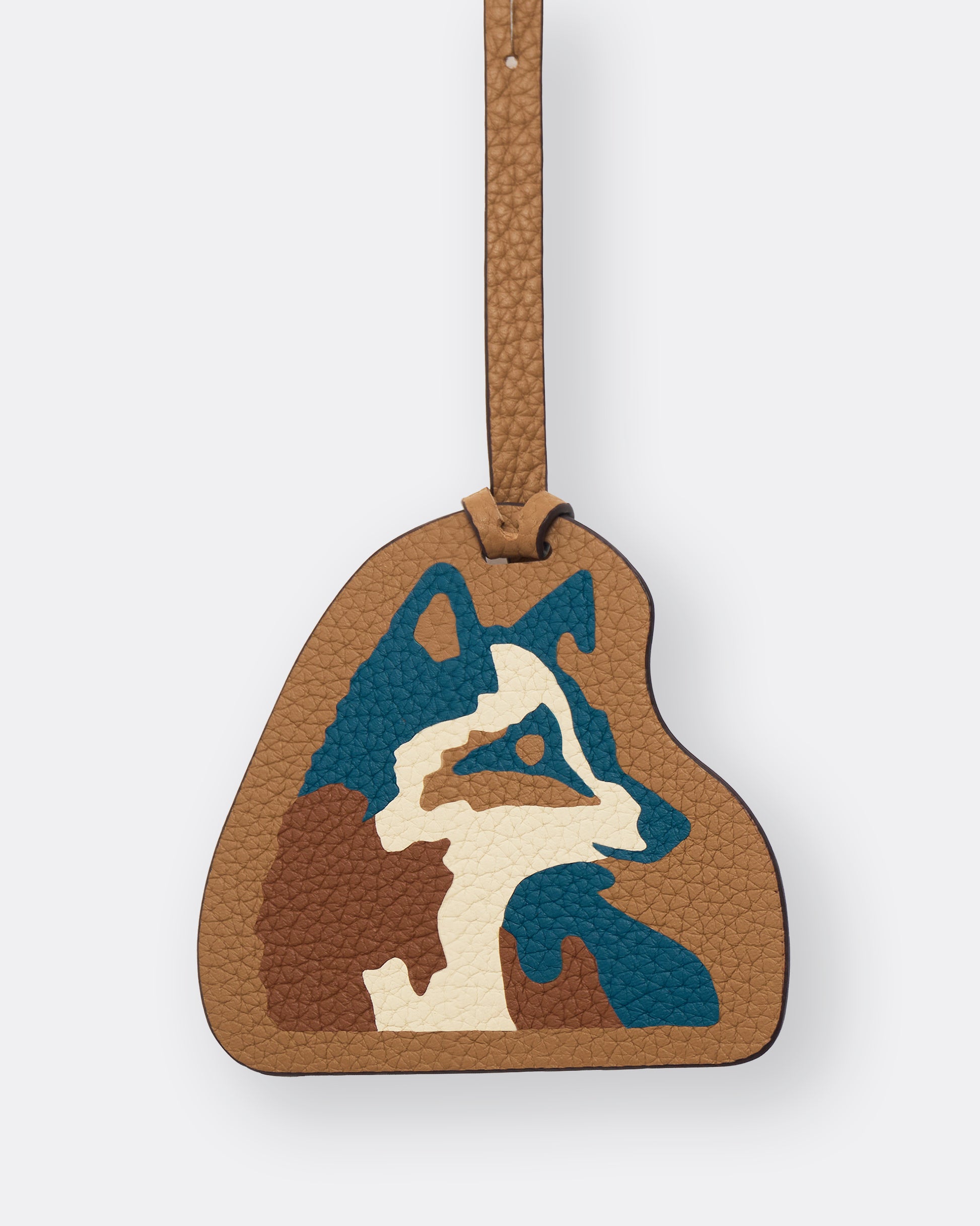Close-up of teal and cream fox leather marquetry inlay on tan leather bag charm
