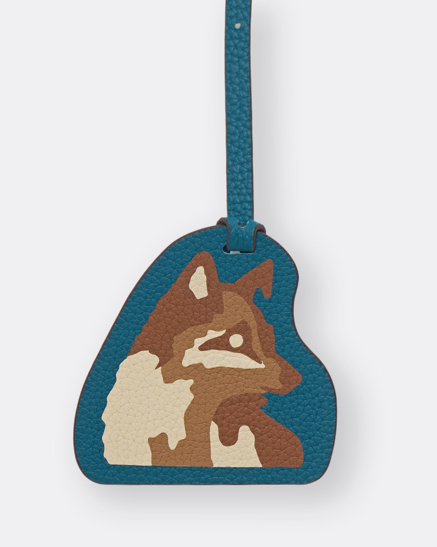 Close-up of Kitsune fox leather marquetry inlay on teal leather bag charm
