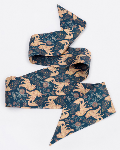 Woman wearing the Kitsune Teal Desert silk bandeau as a hair tie — Studio Qiling hand-drawn kitsune fox luxury silk bandeau Singapore