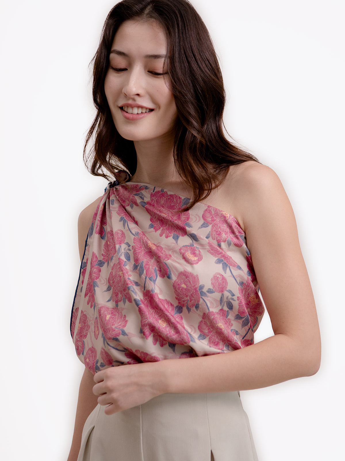 A woman wearing a pink floral patterned silk scarf 