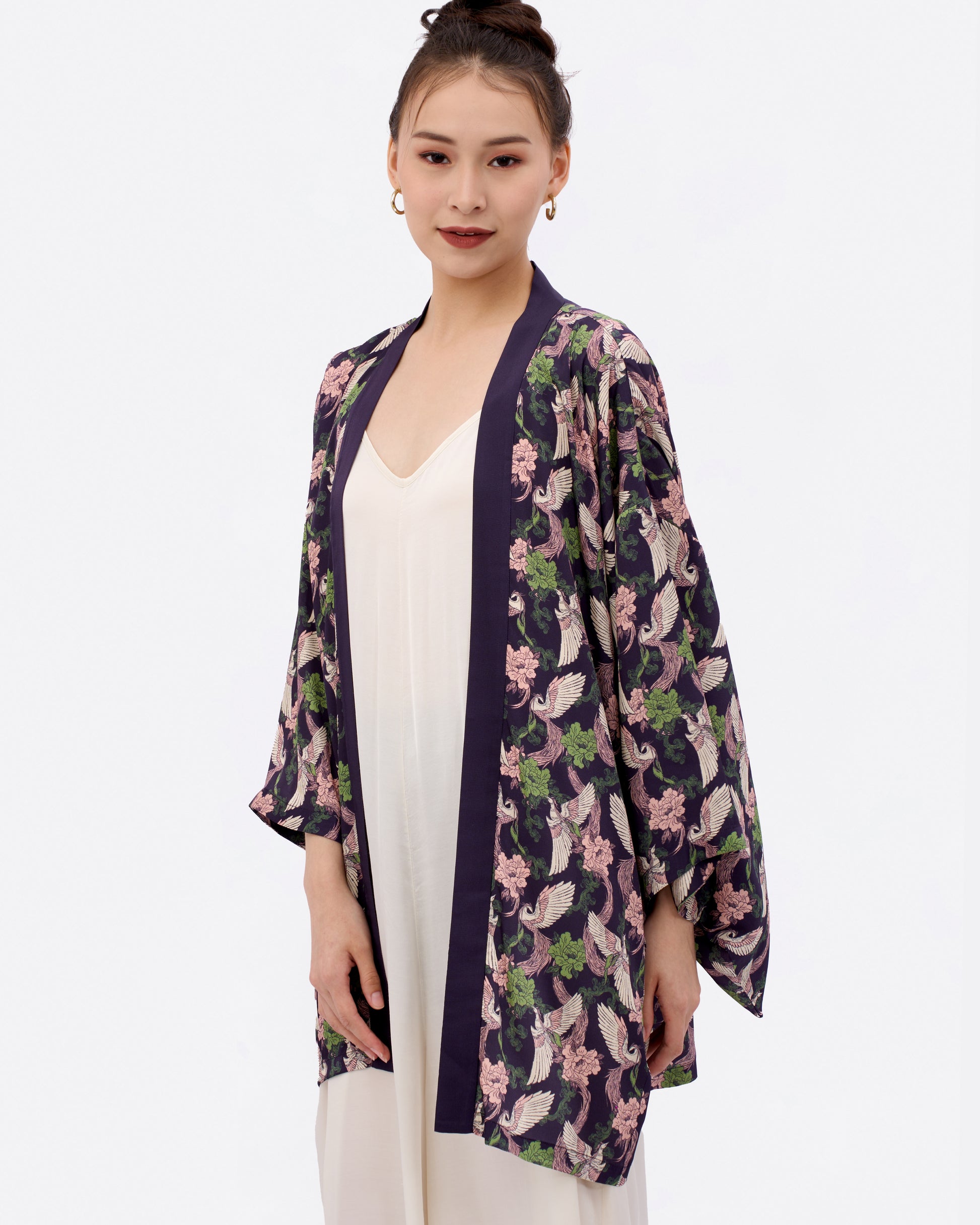 Woman wearing a japanese style kimono outerwear with hand-drawn phoenix print over a white dress