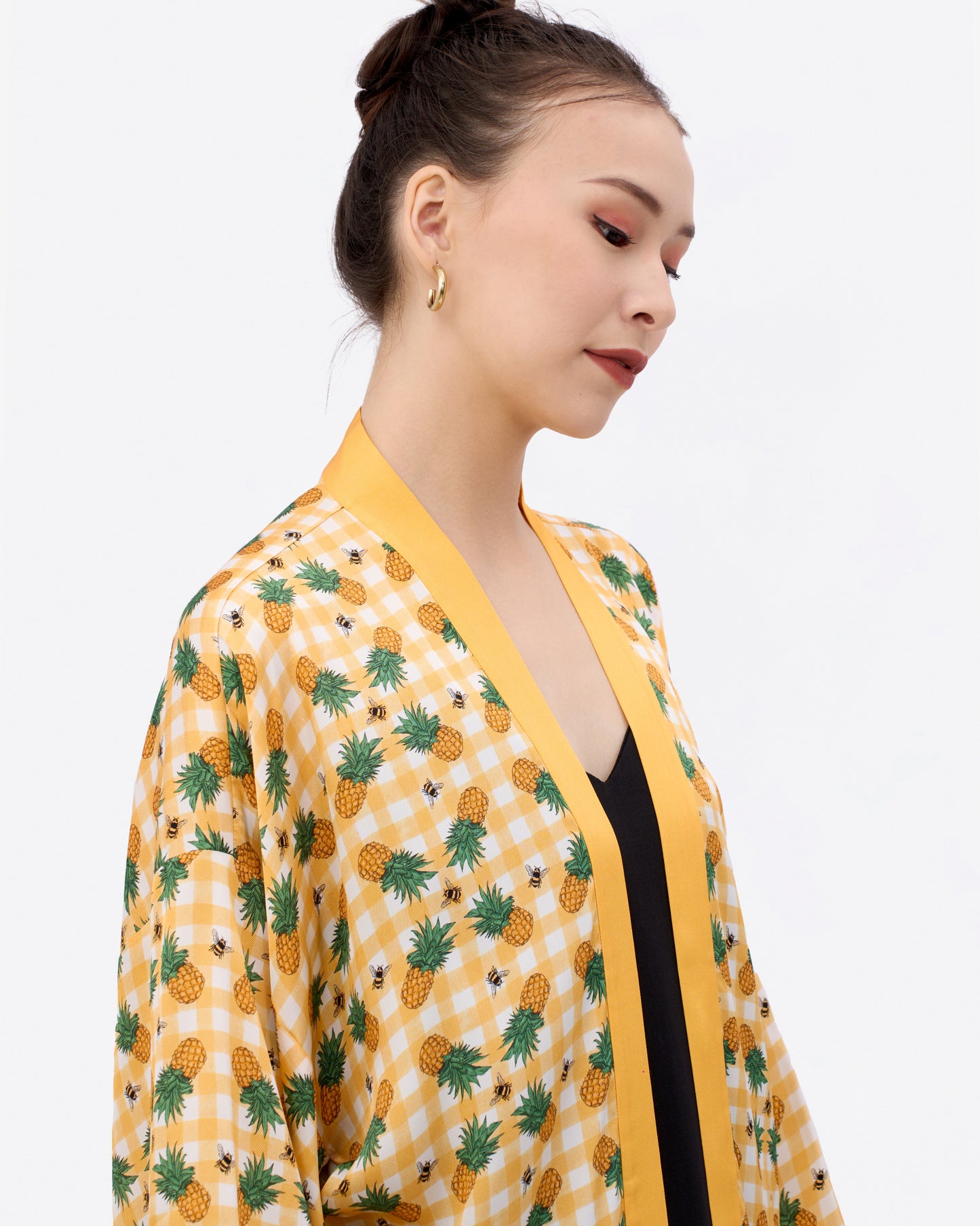Woman wearing a yellow kimono-style silk blend outerwear with pineapple gingham pattern