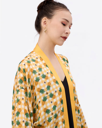 Woman wearing a yellow kimono-style silk blend outerwear with pineapple gingham pattern