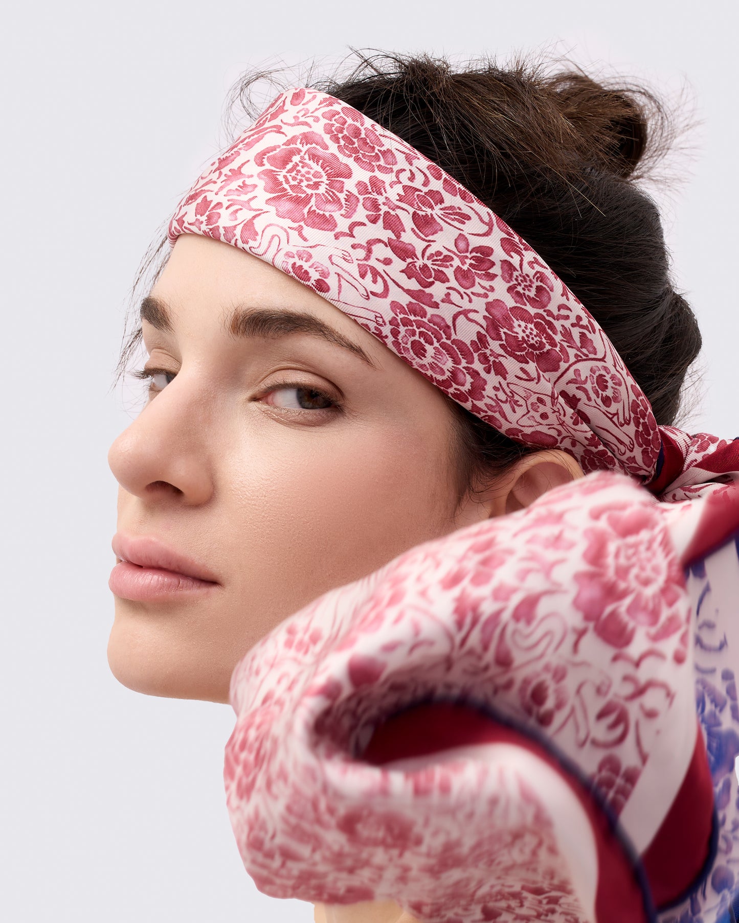 Woman wearing a red and white silk scarf as a headband 