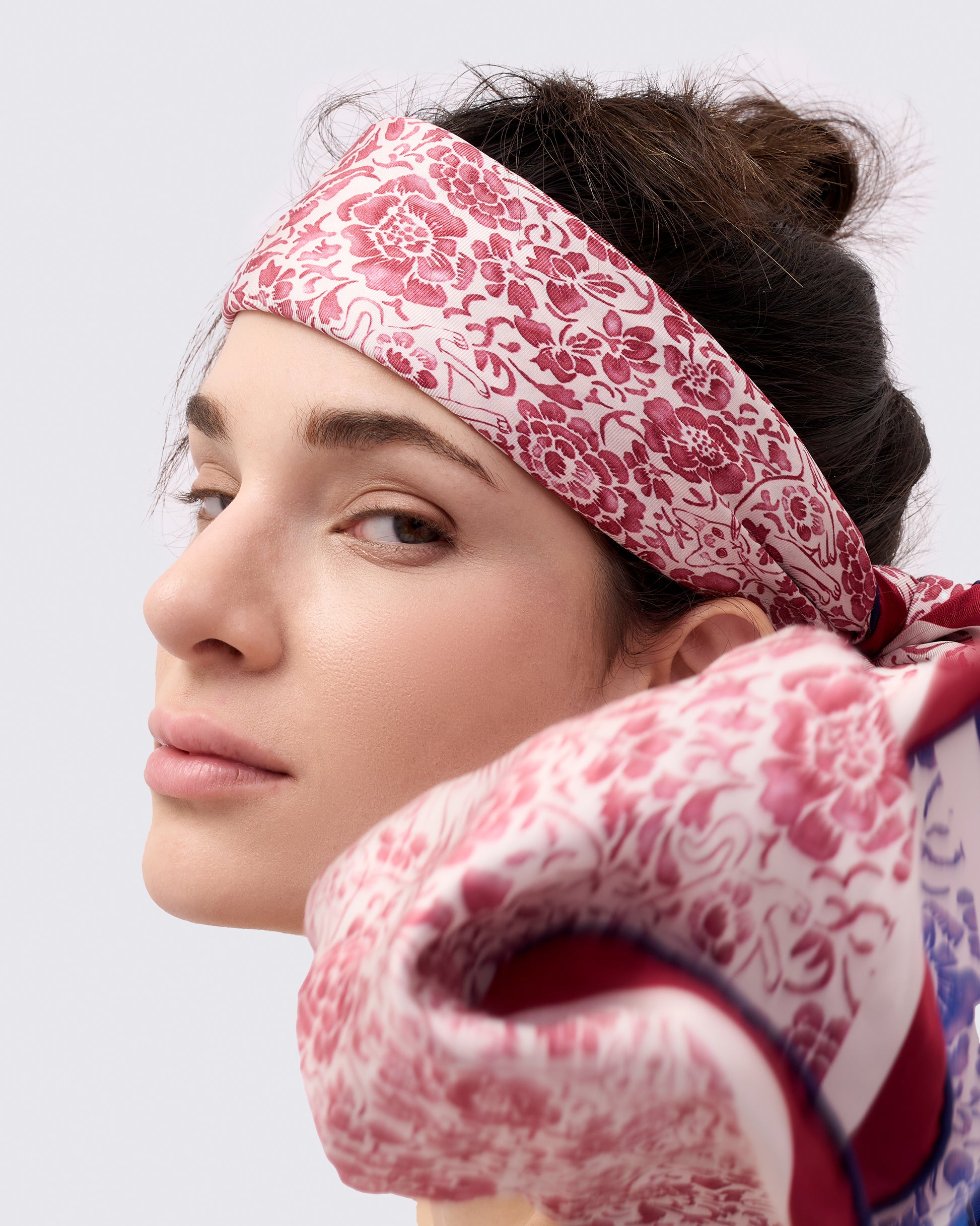Woman wearing a red and white silk scarf as a headband 