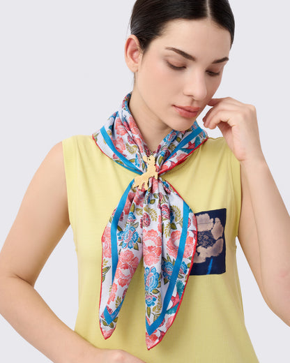 Woman wearing a reversible silk scarf with hand-drawn batik design with florals and crimson sunbird design