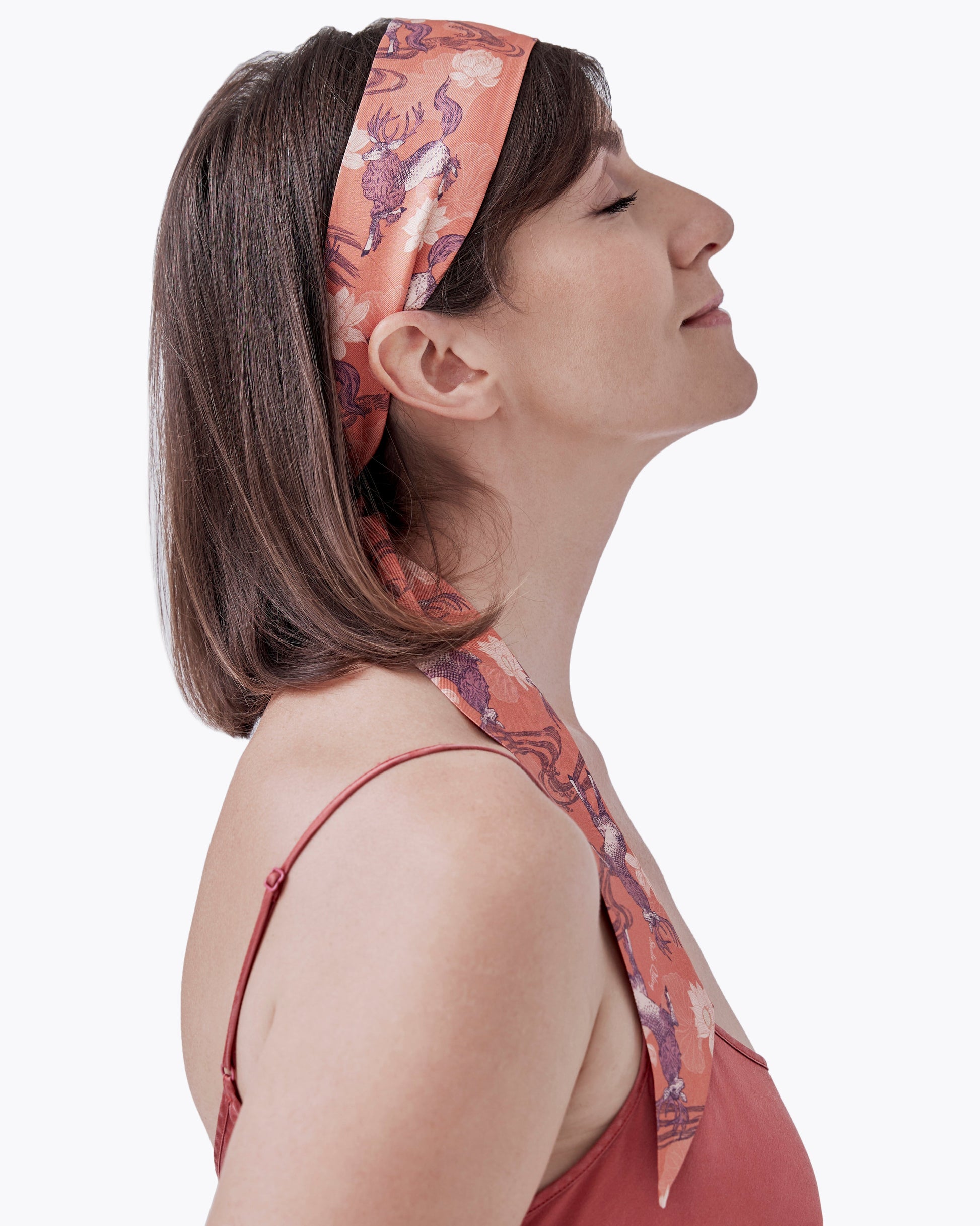 Woman wearing Qiling Mauve silk bandeau as a hair tie — Studio Qiling hand-drawn Qilin print luxury silk bandeau Singapore