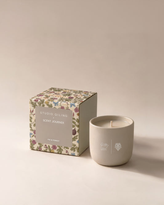 Studio Qiling Fig & Forest scented candle in a decorative jar with its box, showcasing a natural and inviting fragrance.